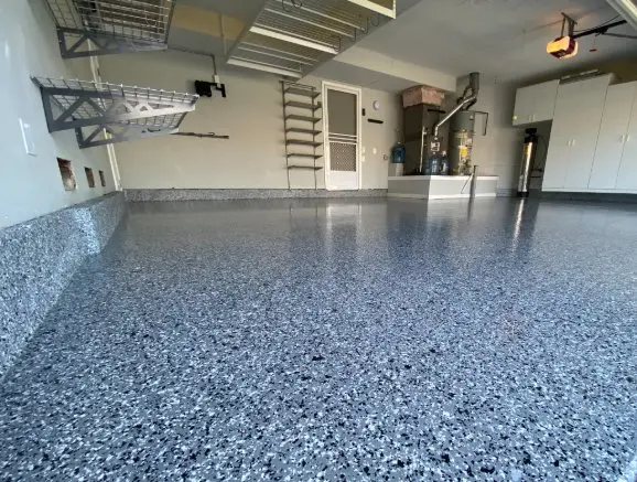 Gray flake epoxy coating in residential garage with storage racks